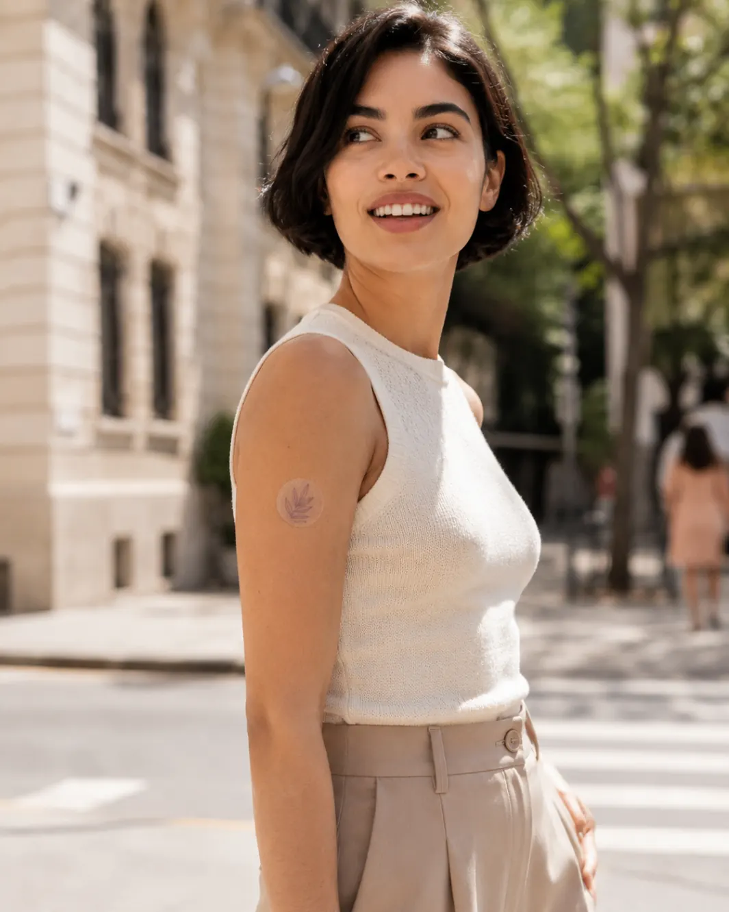 Woman on a sunny European street wearing an AuraVita patch